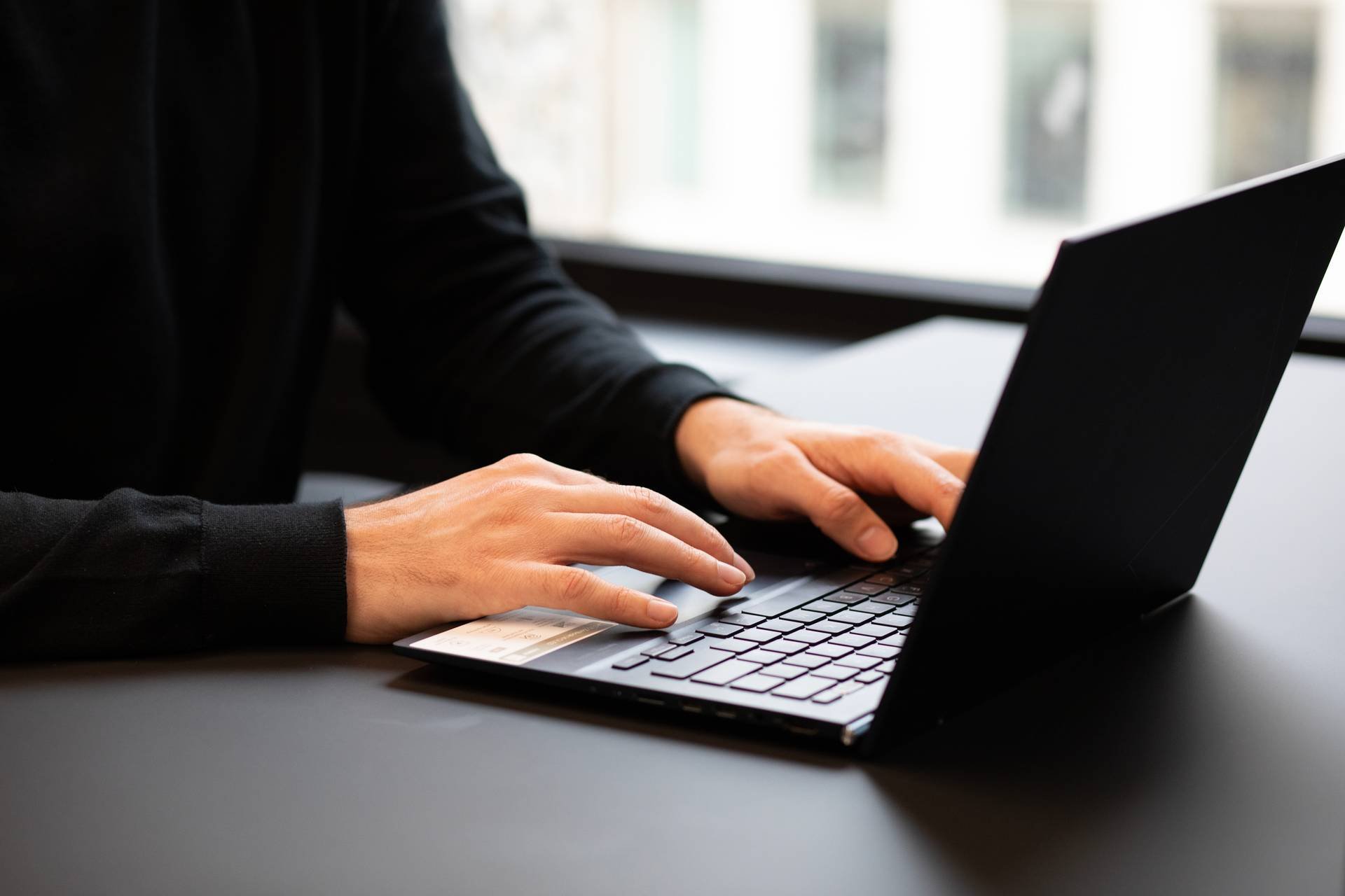 Hender skriver på en pc