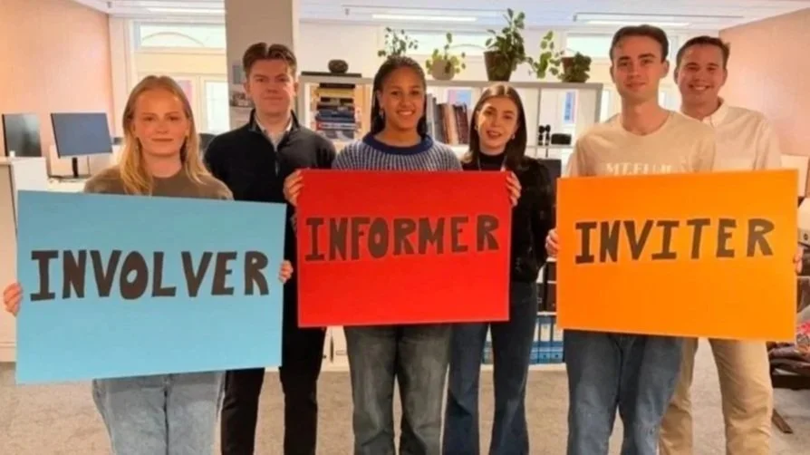 unge mennesker holder opp plakater med teksten involver, informer, inviter på
