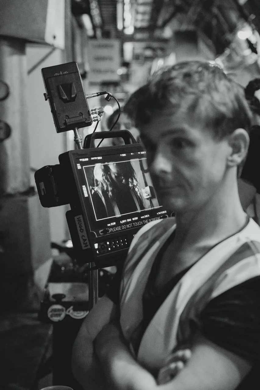black and white photo of a director looking stressed with a camera in the background at the tunnels london