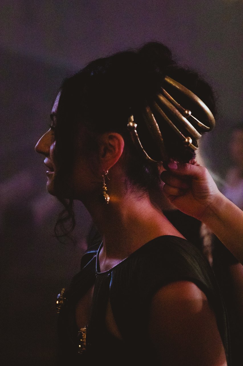 Close up soft cinematic portrait of actor having a gold clasp attached to her head lit by overhead lights at Earth Studios Dalston London 