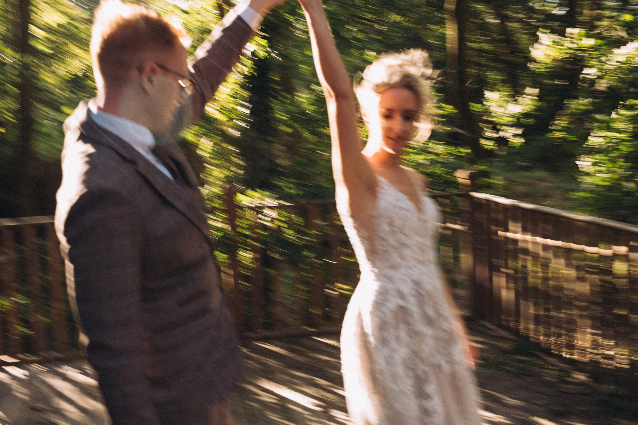 editorial blurred artistic abstract photo of bride and groom twirling in the setting sun in the woods at artisan bohemian Upthorpe Wood Bury St Edmunds Suffolk 