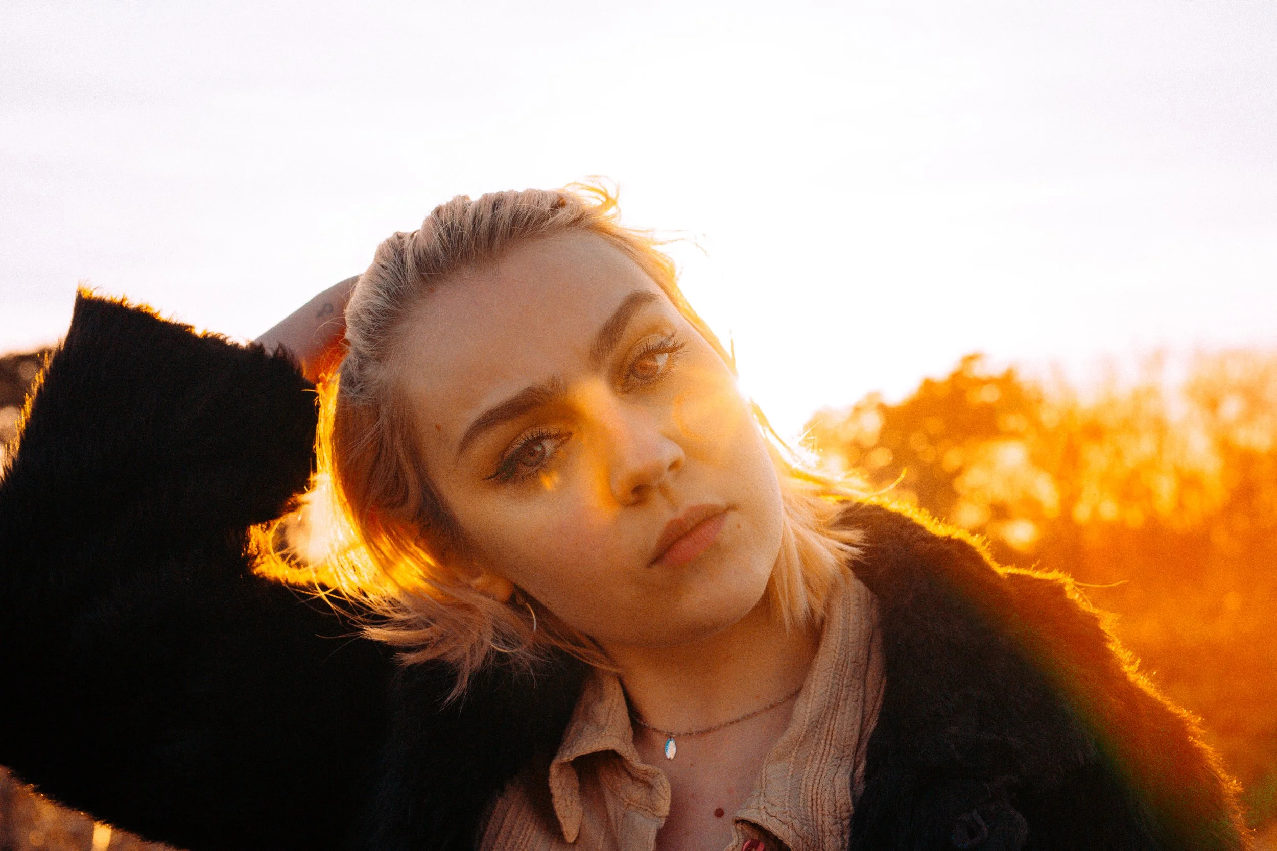 Warm golden lit hour portrait at sunset of blonde actor on Corton Cliffs Lowestoft Suffolk 