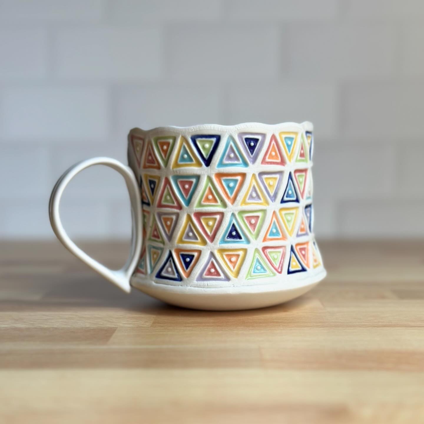 Good morning friends!  How are you doing?  Here is a mug I made. In lieu of a more creative title, I call this design Triangle Quilt.  Any suggestions for something better are welcomed. 😁 this is ^6 porcelain with celadon glaze in the stamped areas.