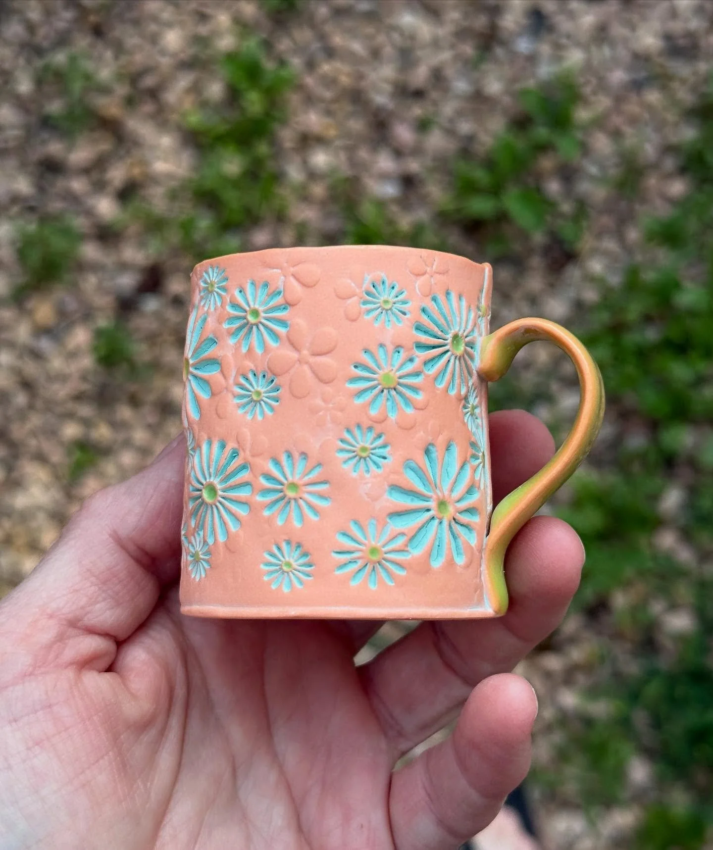 I&rsquo;m thinking this wee muggy has a kind of southwest/adobe vibe.  Details:
Colored porcelain&mdash;@lagunaclay #550 stained with Lobster mason stain
Daisies are flooded with color&mdash;provided by @amacobrent Seafoam velvet underglaze 
The inte