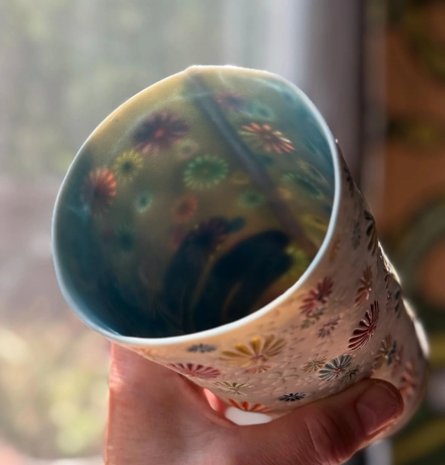 Rainbow Daisyware pint glass over here glowing in the sunlight. Available in tonight&rsquo;s shop update!  Preview is up now!  Get on my email or text list for early shopping. 
🌈🌼🌸🌺🌻🌹🌷🪻🌈
#shopsmall #supportsmallbiz #smallbizlove #smallbusine