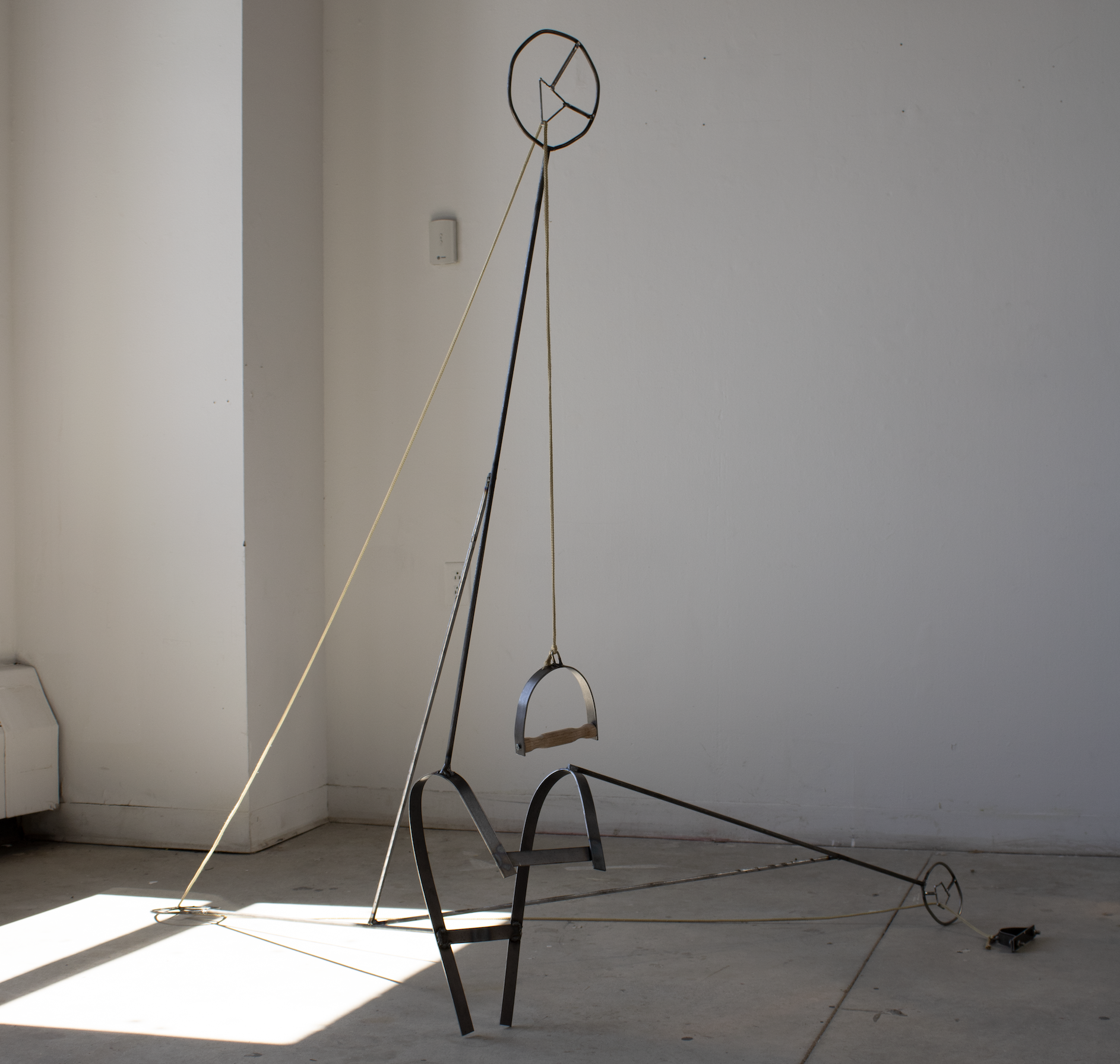 "Puppet/Submarine", 2024. Steel, wood, rope. An exercise in futility: the user is shackled to the work, and uses the handle to extend the arm.