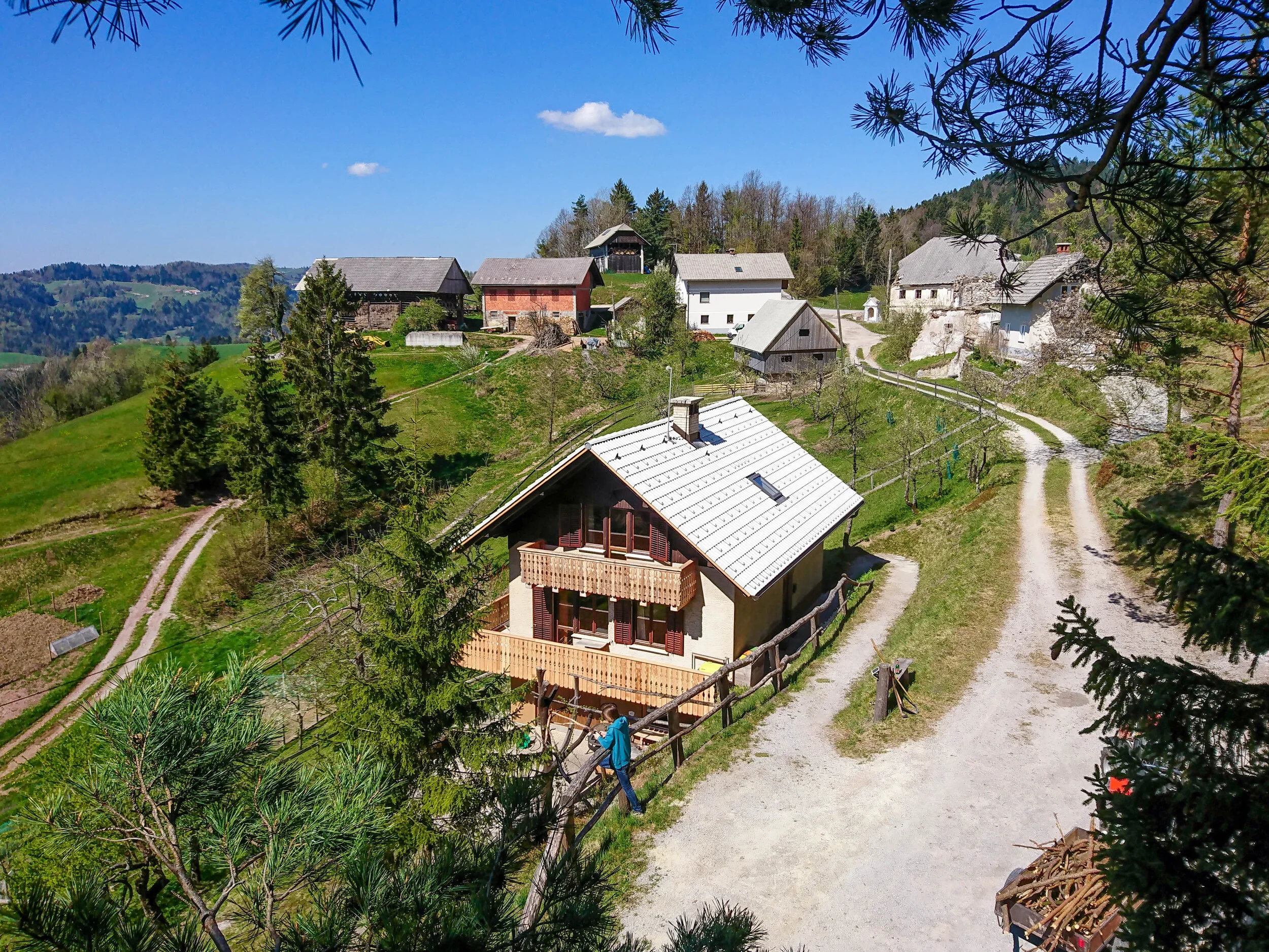 Image of the Pr' Popr accommodation. Big house in the hills, barn in the background along with some more buildings.