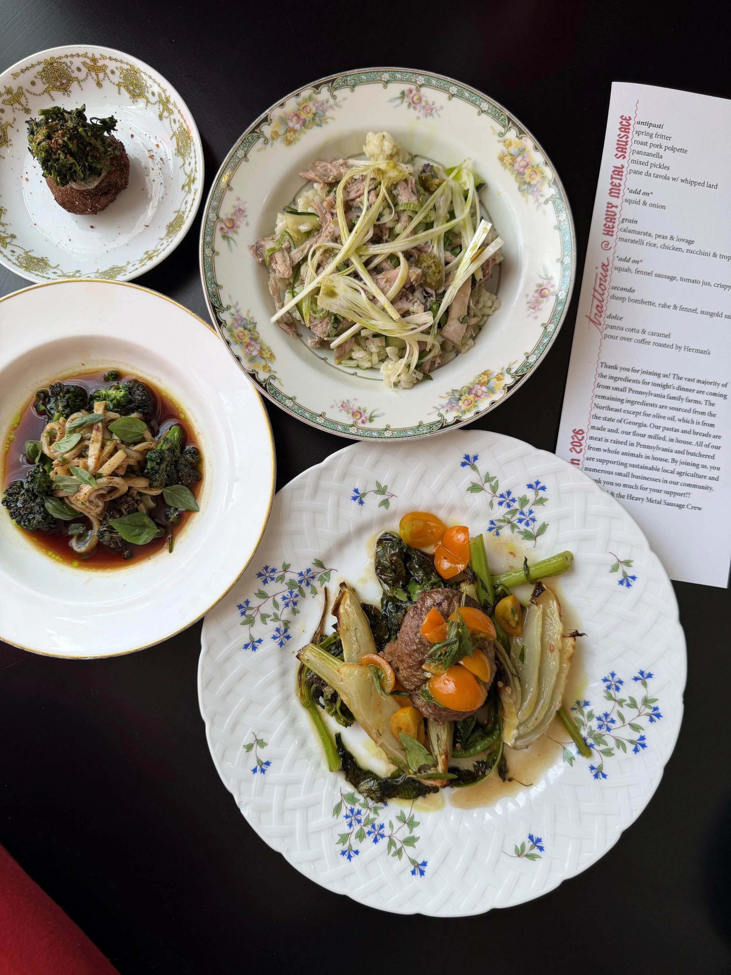 Assorted Italian dishes including pasta, vegetables, and a meat dish on decorative plates, with a menu on the side.