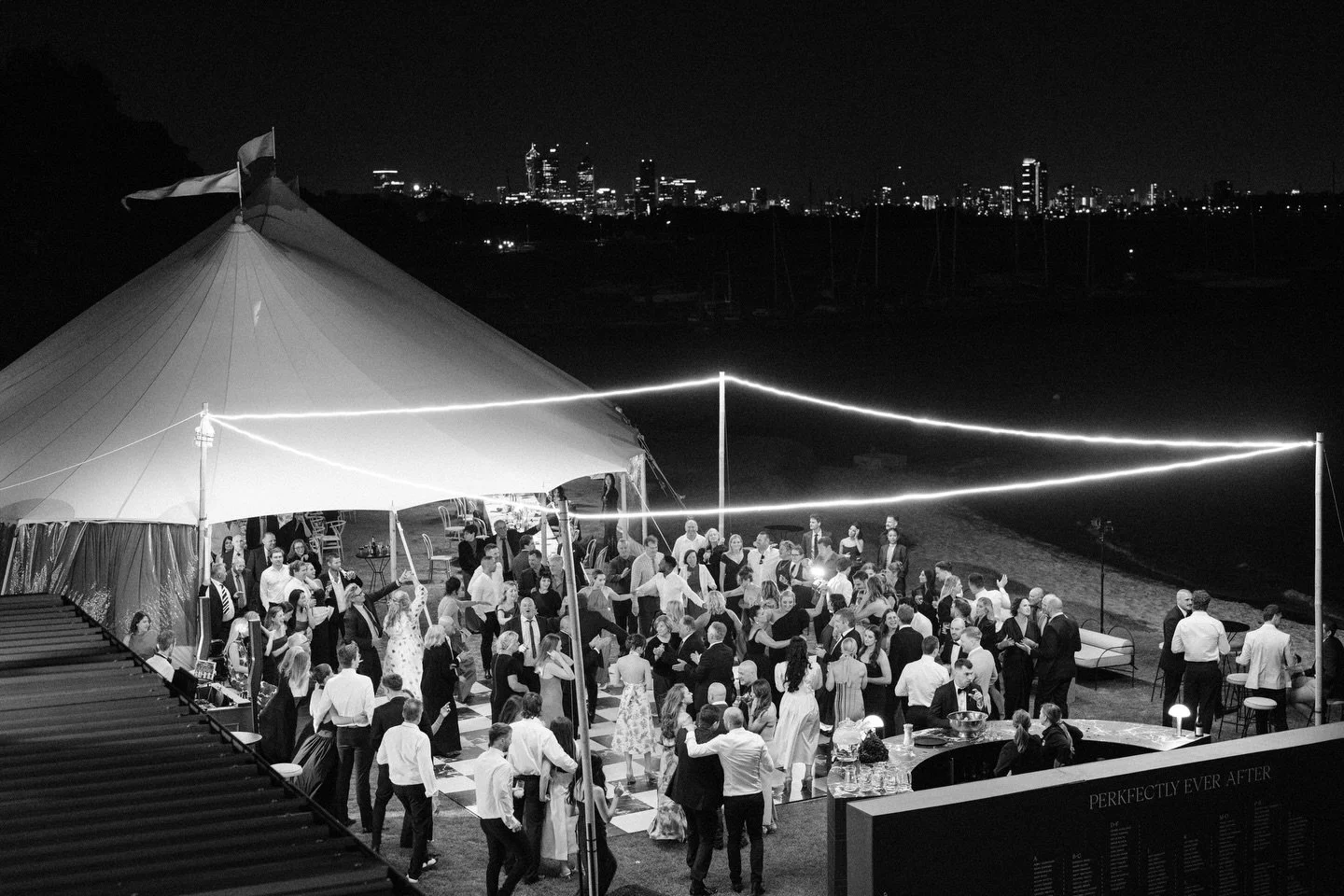 When the sun sets and the lights come up, the real magic begins.

Stef &amp; Dan&rsquo;s celebration transformed under the stars&mdash;a sperry tent framed against the Perth skyline, geometric lighting carving out the dance floor, and their people ga