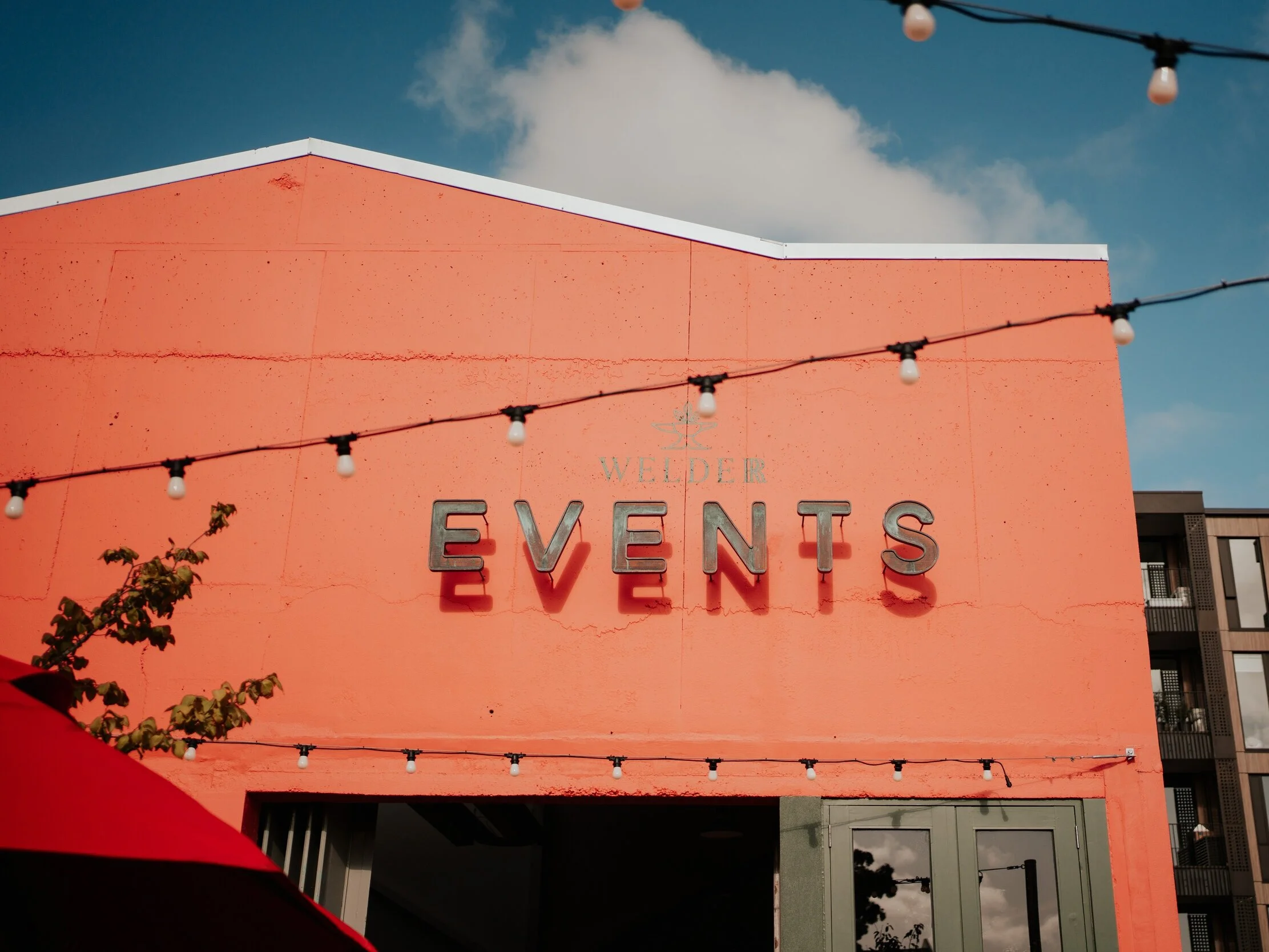 The Welder  113 Sqm Industrial space with recycled heritage wooden flooring this event space is the perfect blank space to create your perfect event. Located at the rear of The Welder complex with a dedicated events entrance, your guests will be captivated the moment they walk into the private outdoor courtyard area. Then enter into this event oasis though the original green henderson track door, originally housed in the Landrover workshop and parts department back in the 60's, adding to the spaces rustic charm.   Capacity  220