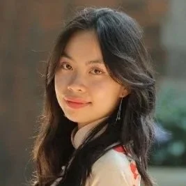 Portrait of a smiling young woman with long dark hair outdoors