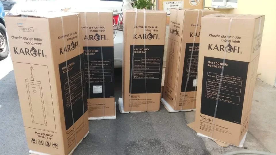 Five Karofi drinking water purifier boxes stacked outdoors beside a vehicle.