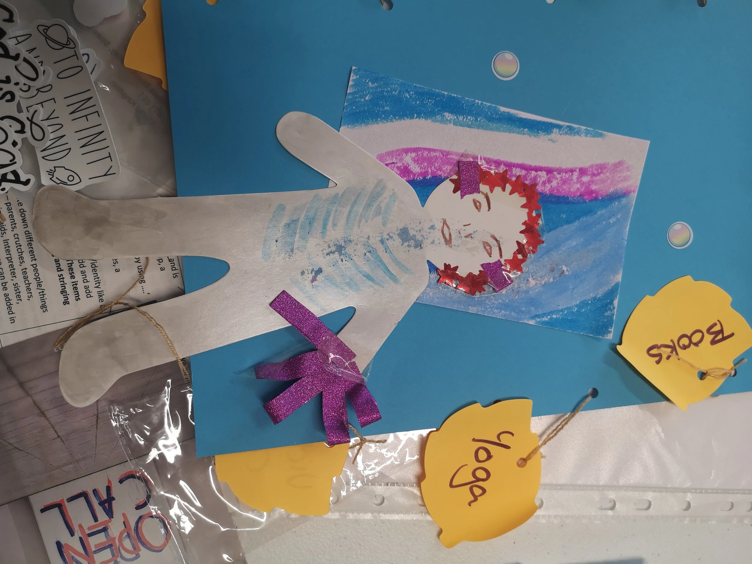 A anon on a blue background half stuck on the paper with a life like face and red hair with words around in yellow speech bubbles.