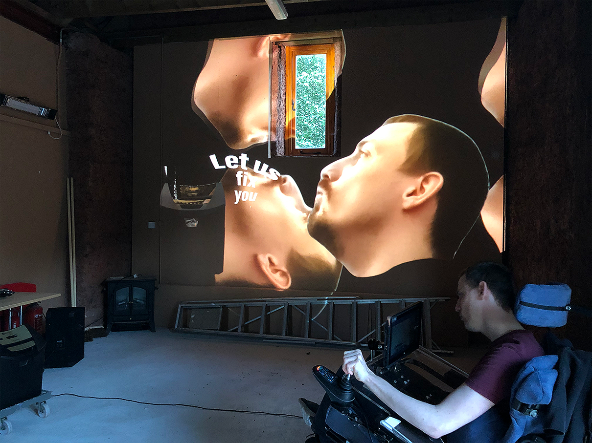 wheelchair user in a burgandy top watches projection of his own head multiplied next to a shredder and text reading: let us fix you