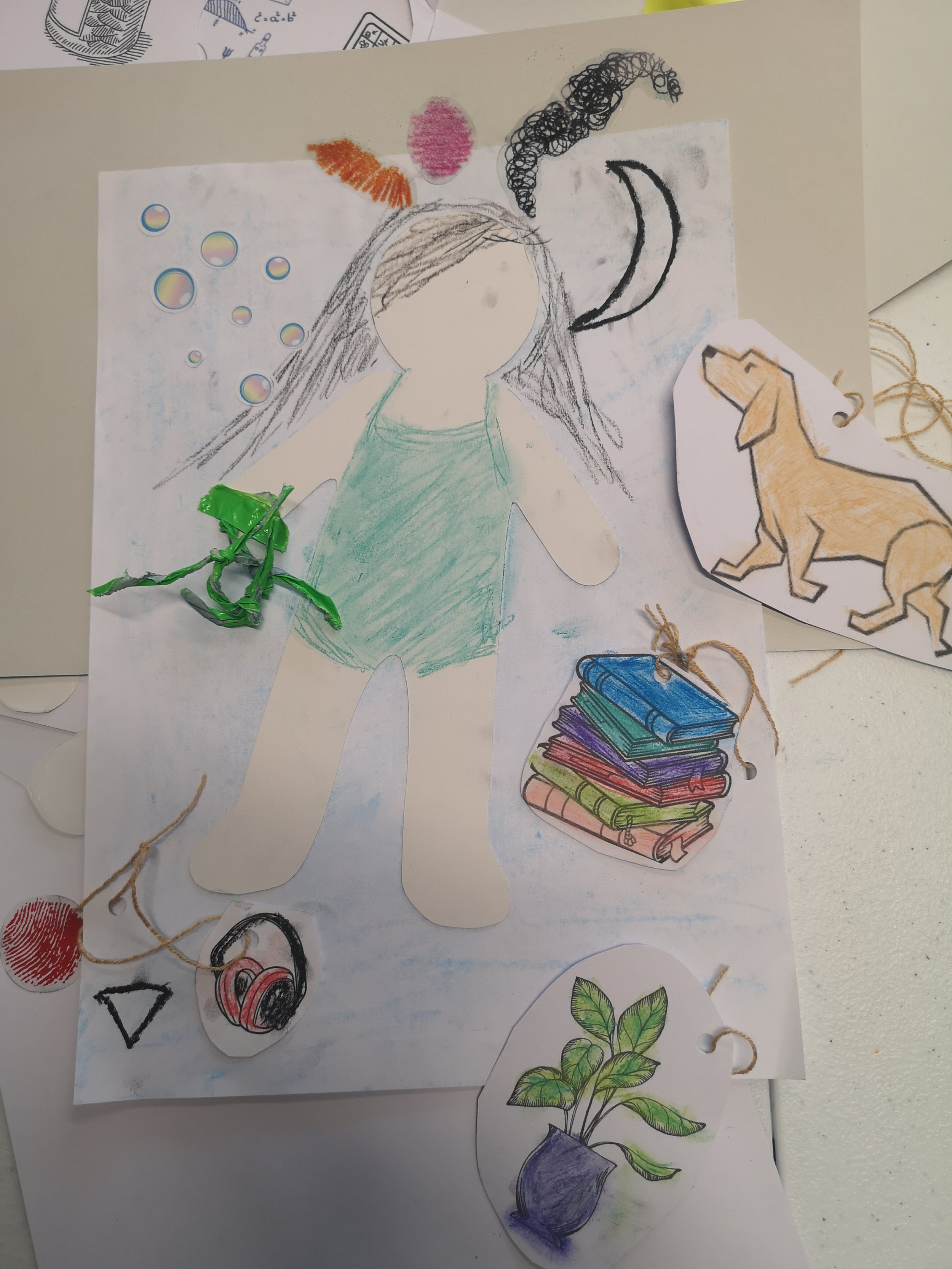 A anon on a white background with dark long hair and pictures of a dog, books and a plant around .