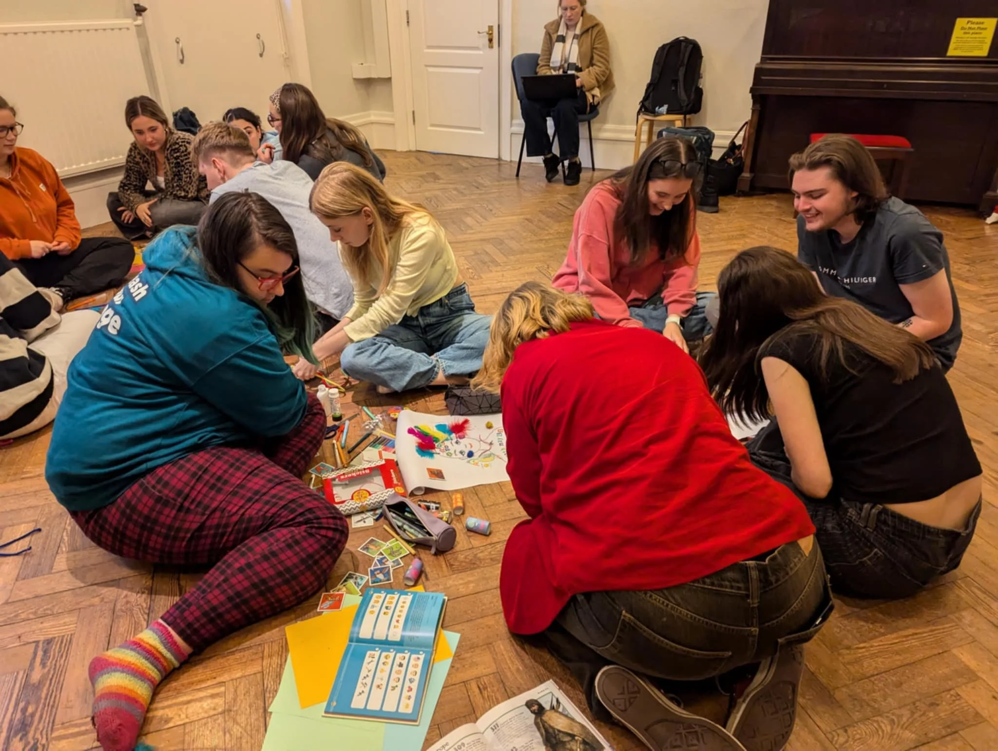 Two group of student sitting on a floor around making equipment.