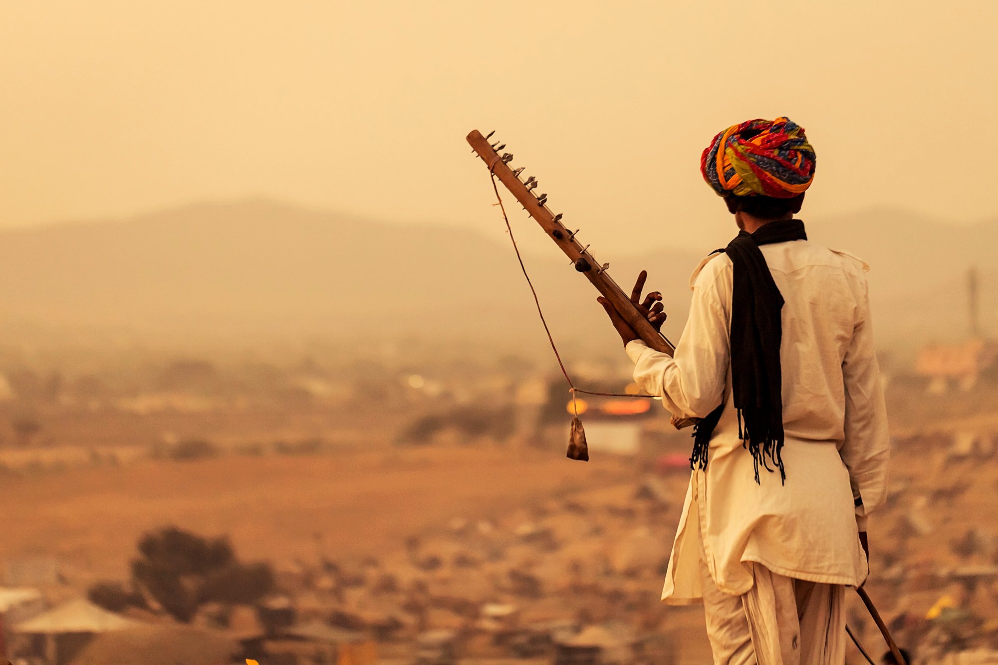 Musician, Pushkar
A local musician in Pushkar, Rajasthan, carrying his traditional instrument across the landscape that has shaped his community for generations.