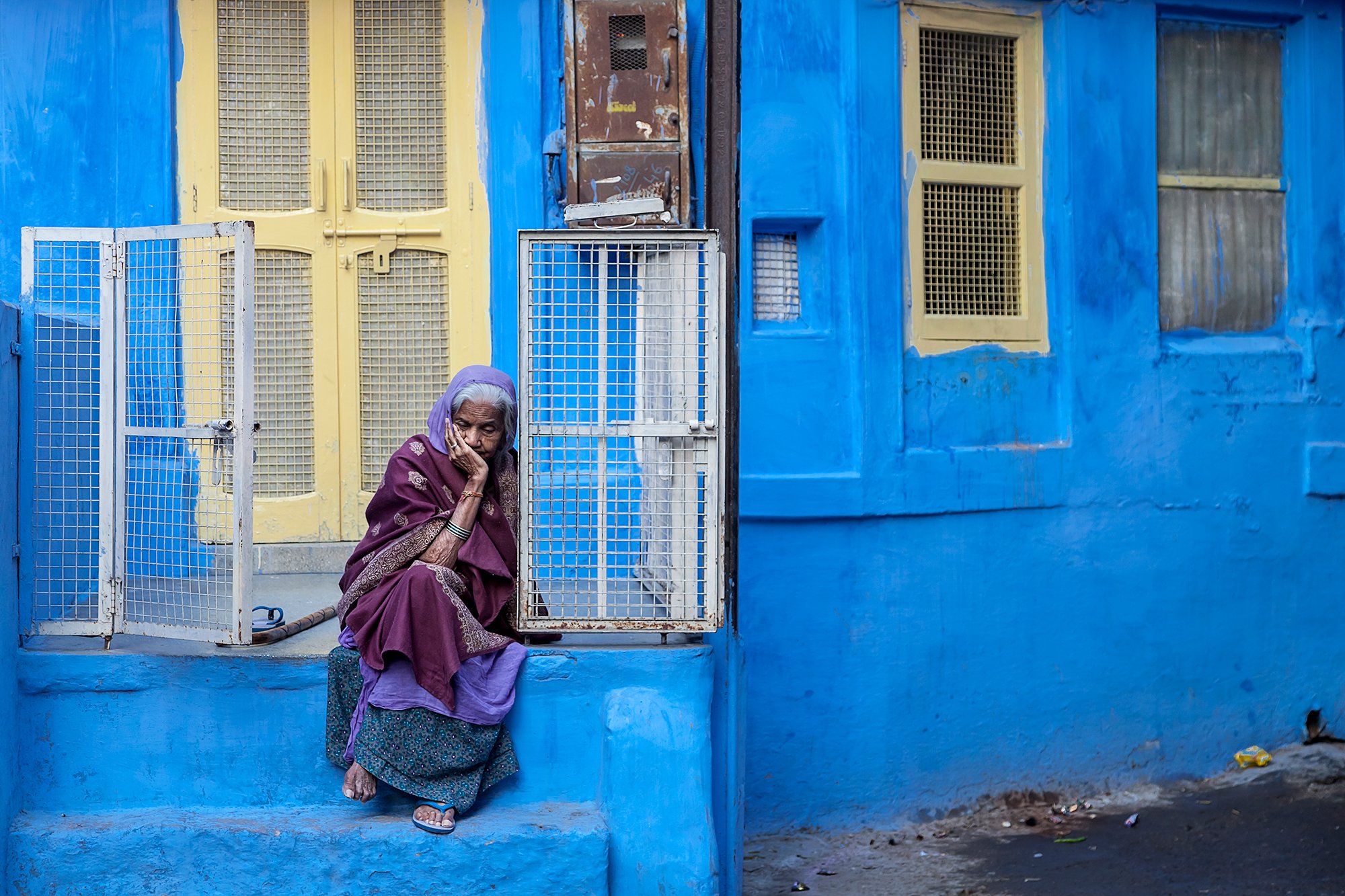 Woman, Jodhpur

An elderly woman sits quietly outside her home in Jodhpur. The city's distinctive blue walls become more than a backdrop, reflecting the place she has long called home.

Jodhpur, Rajasthan, India, 2012