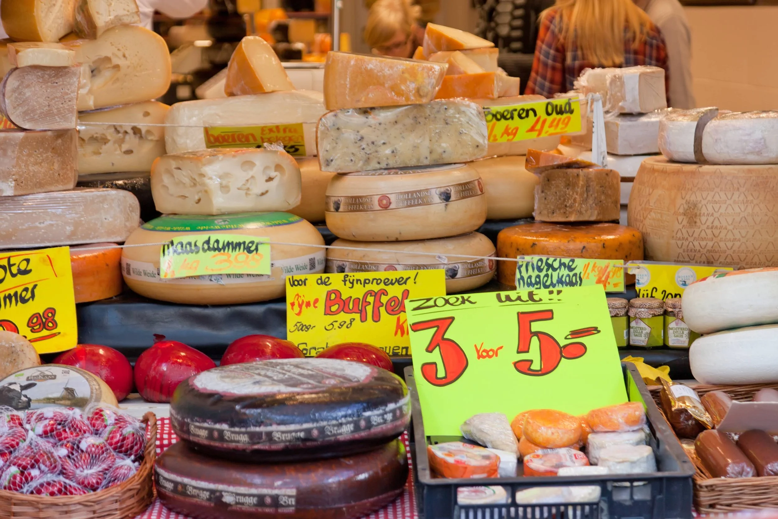 A Dutch cheese shop displays Nagelkaas, Maasdam, and other cheese varieties