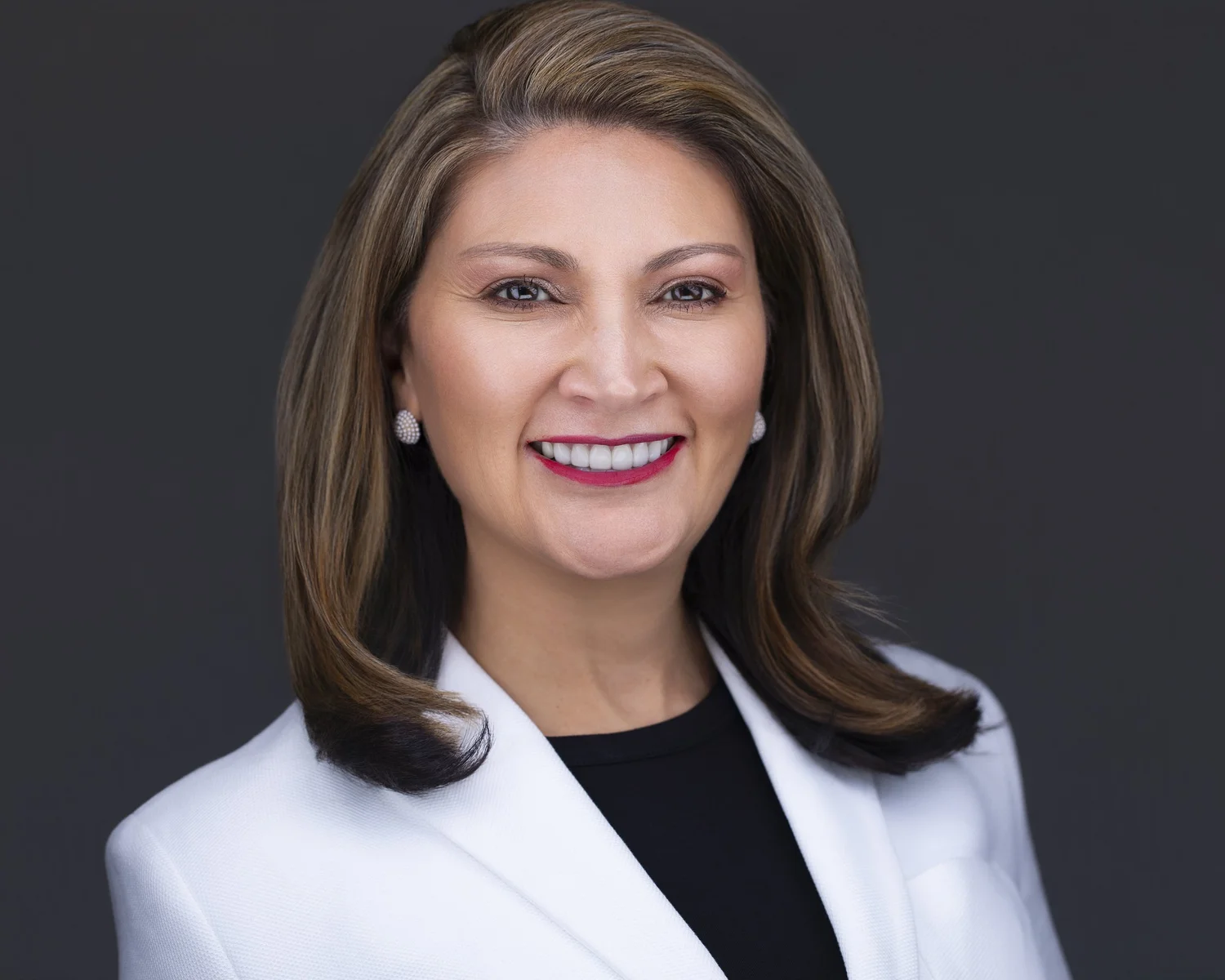Professional studio headshot of Elizabeth in a white jacket, photographed by Godoy Shots