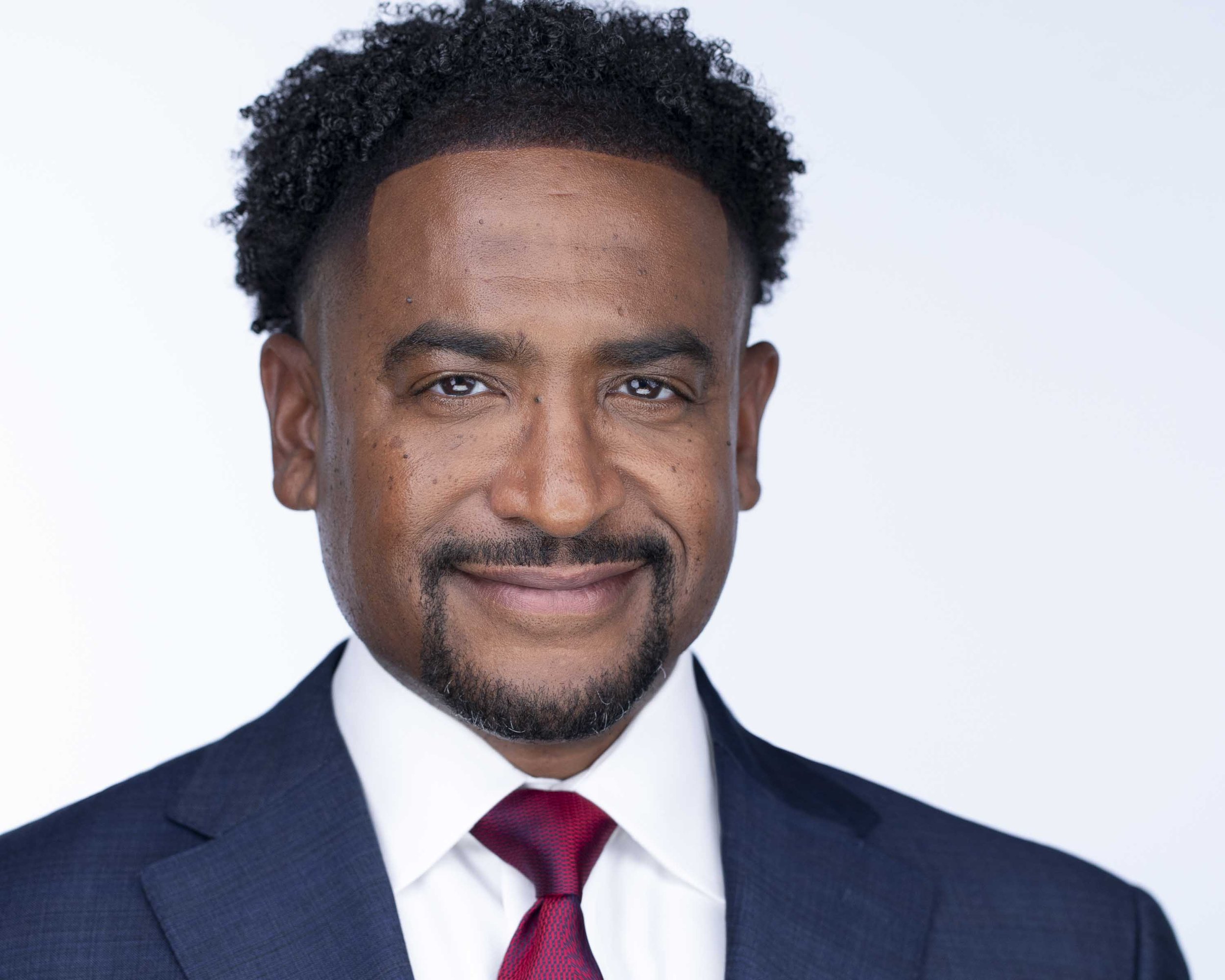 C Level executive in red tie with confident expression photographed for professional headshots in Dallas TX.