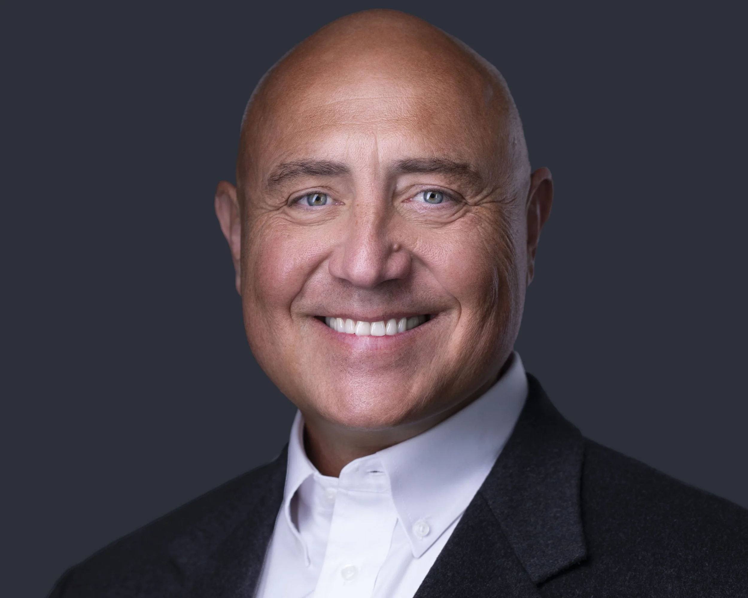 Executive headshot of confident business professional in dark suit by executive headshot photographer Dallas at professional headshots Dallas TX studio