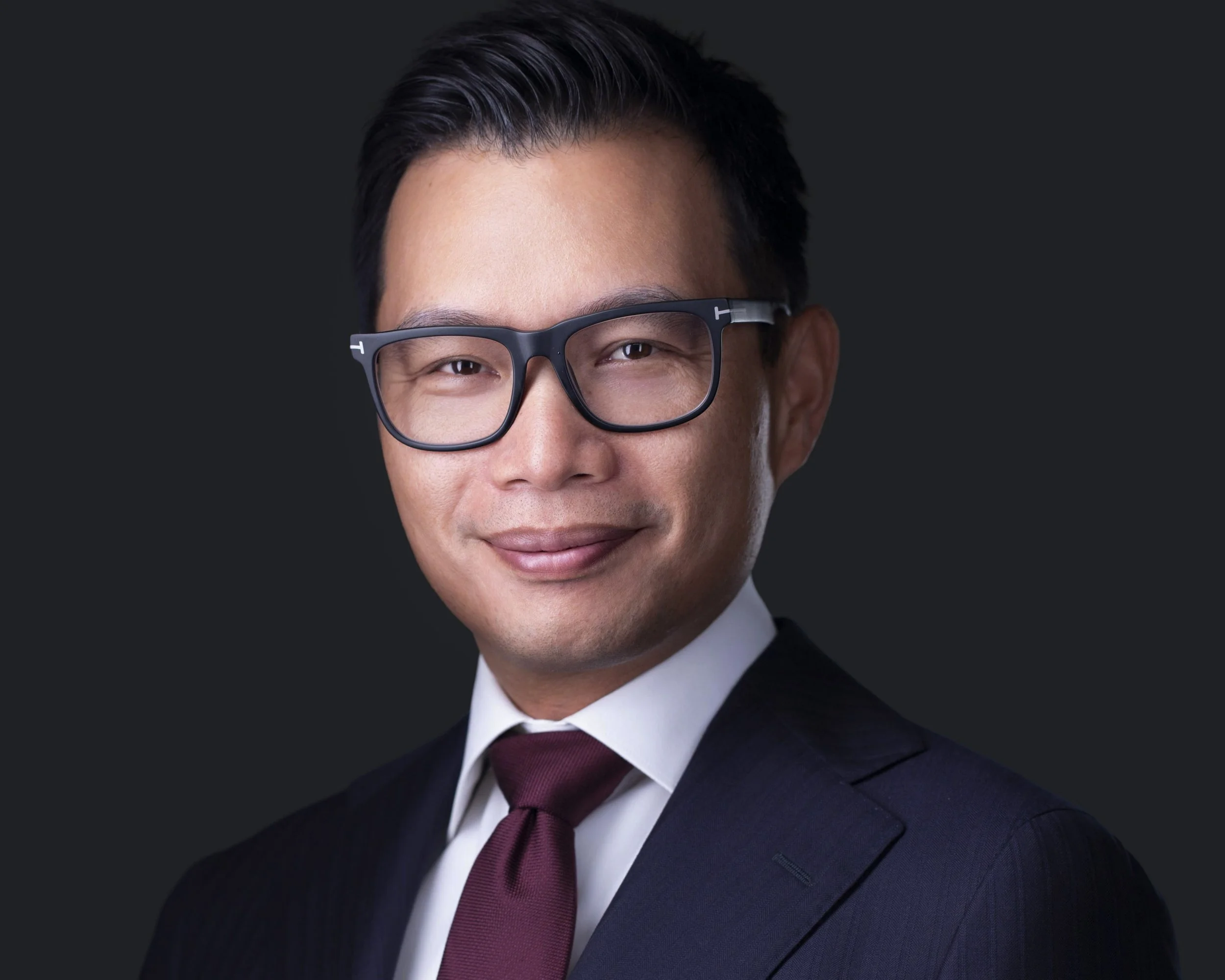 Male executive wearing glasses with confident expression photographed for corporate headshots in Dallas TX.