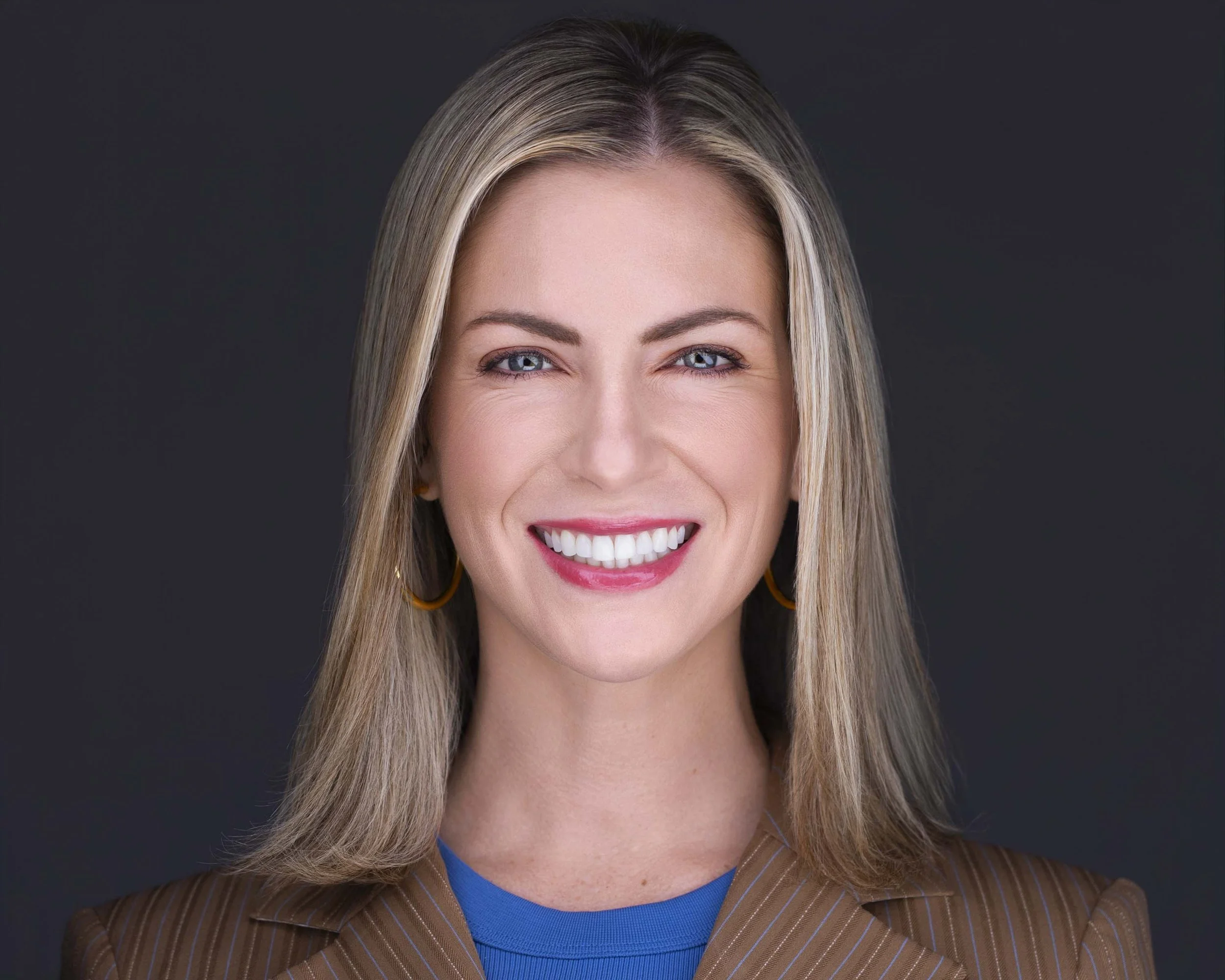 Female executive with natural expression photographed in studio for professional headshots in Dallas TX.