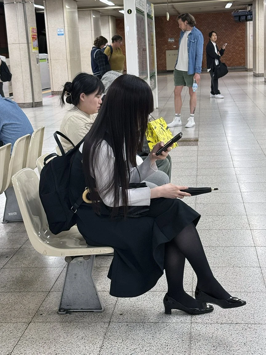 Woman looking at phone, Otemachi Station, 2025
