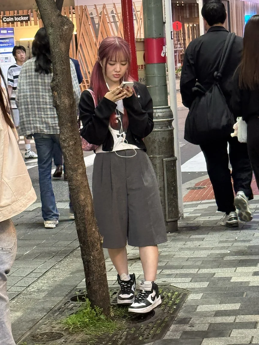 Teenager looking at phone, Ueno, 2025