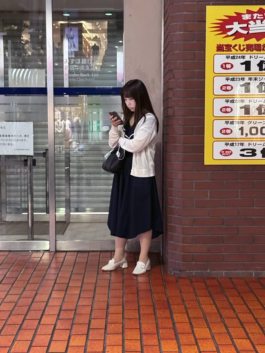 Woman looking at phone, Ojima, 2025