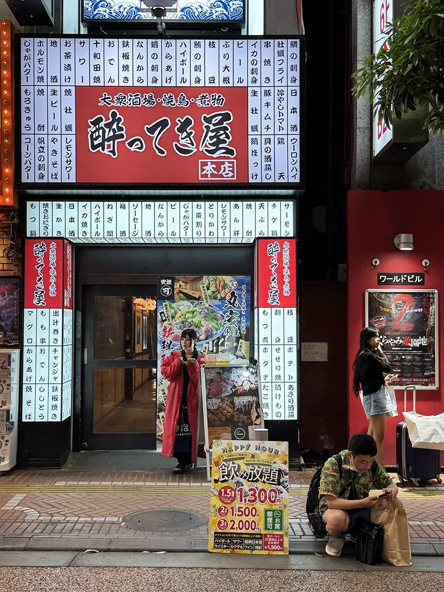 People looking at phone, Akihabara, 2025