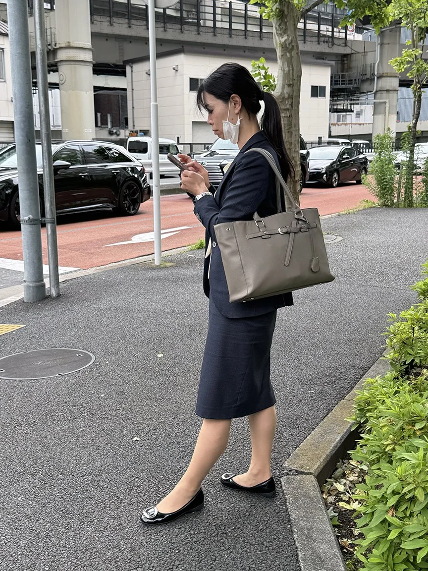 Woman looking at phone, near the Imperial Palace, 2025