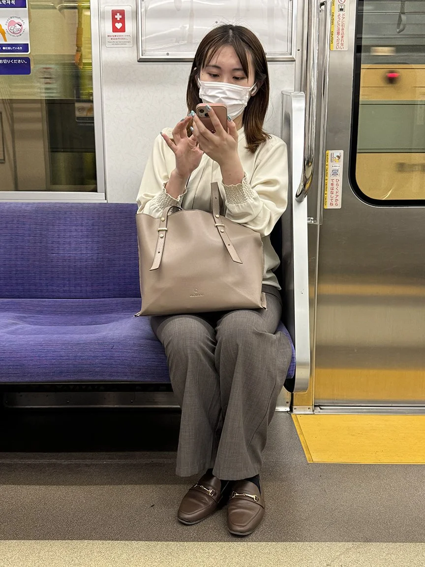 Woman looking at phone, Hibiya Line, 2025
