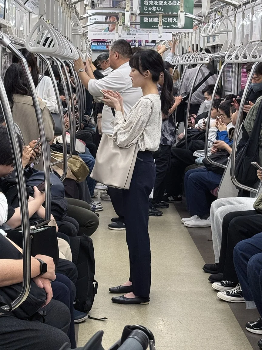 Woman looking at phone, Hanzomon Line, 2025