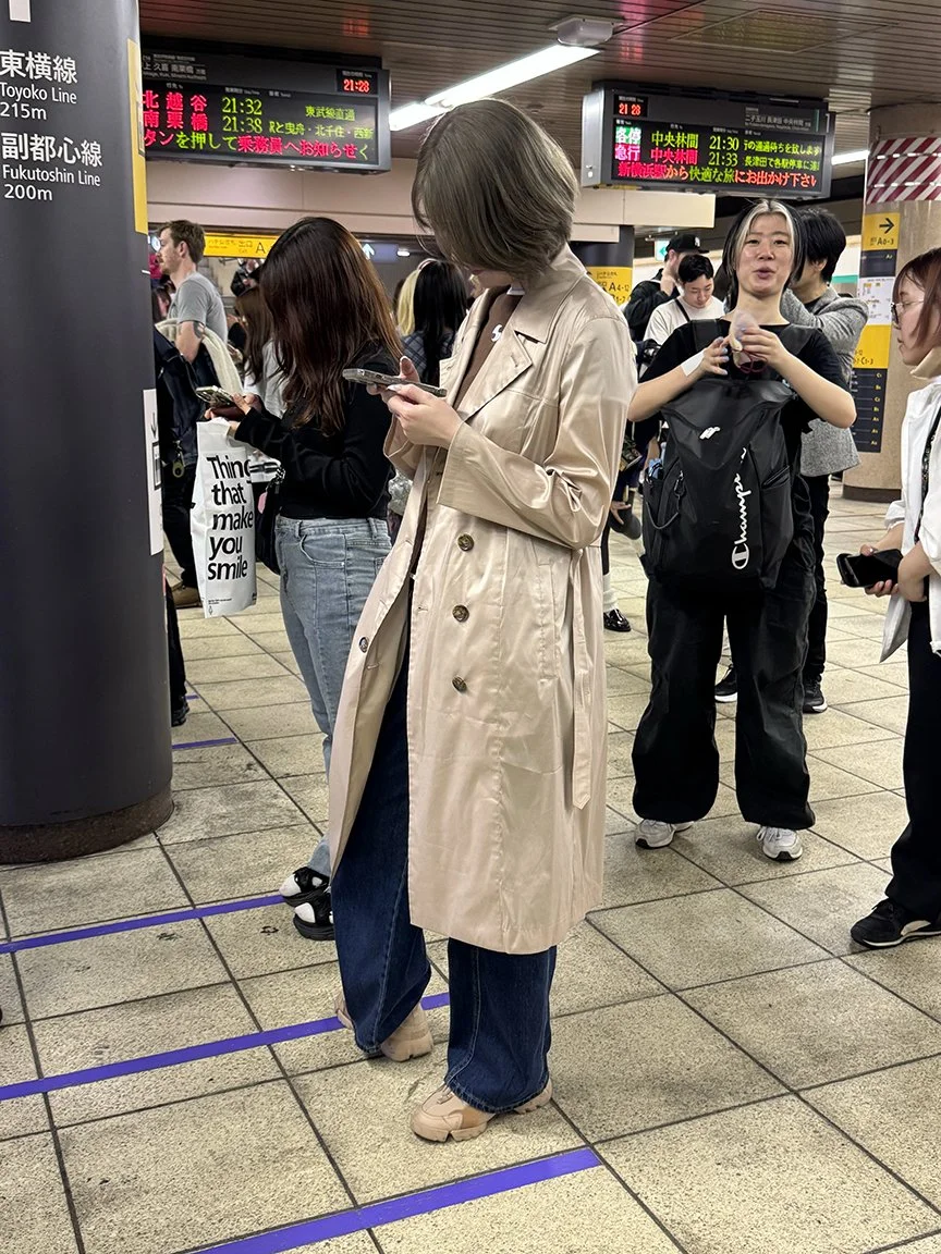 Woman looking at phone, Tokyo Station, 2025