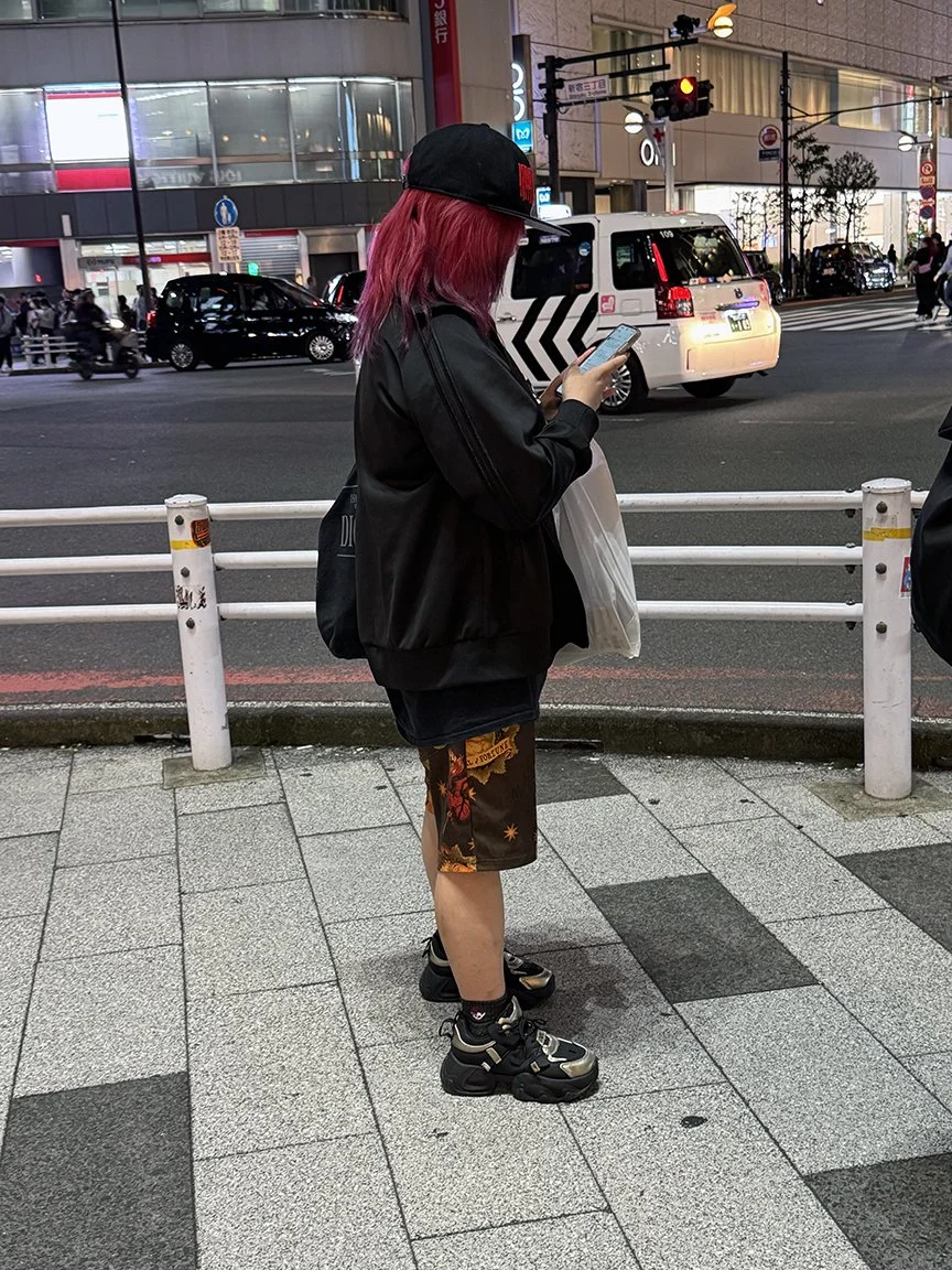 Teenager looking at phone, Shibuya, 2025