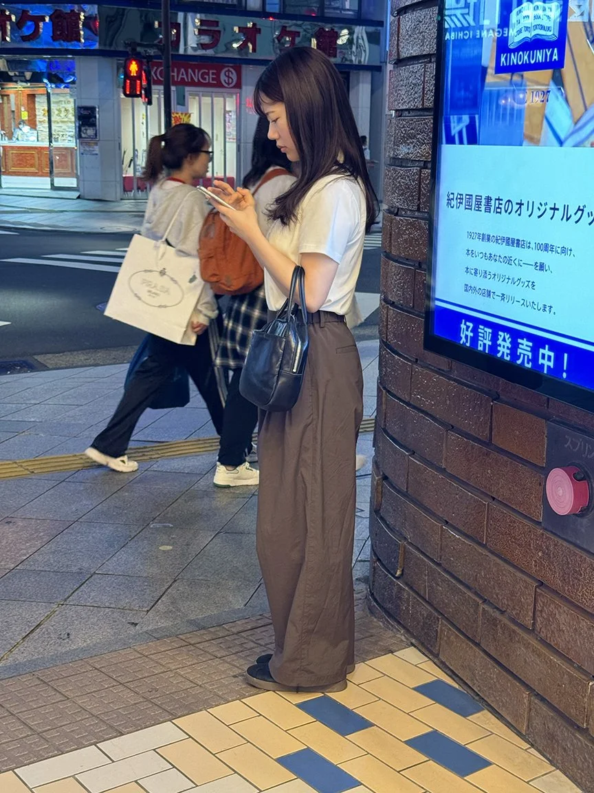 Woman looking at phone, Harajuku, 2025