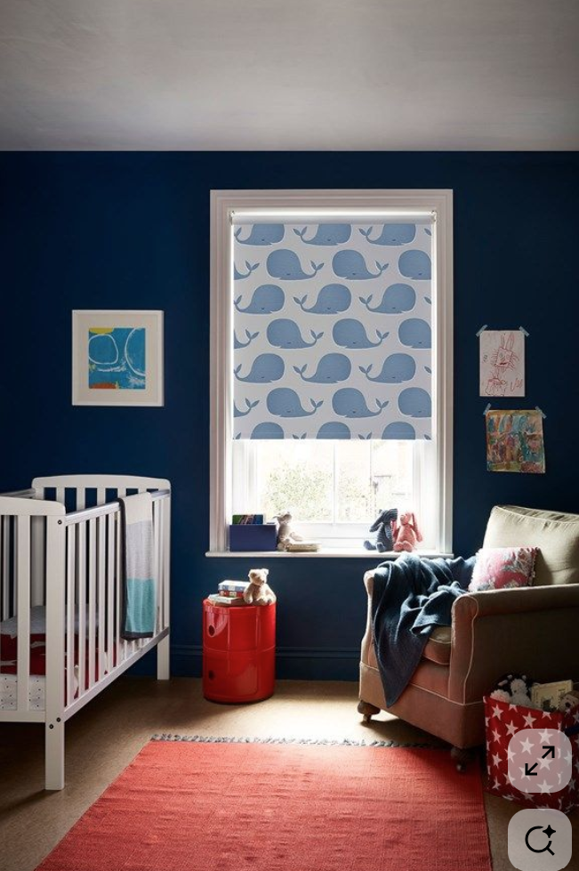 Interior with a window covered by a printed roller blind featuring a green botanical pattern, with potted plants in the corner.