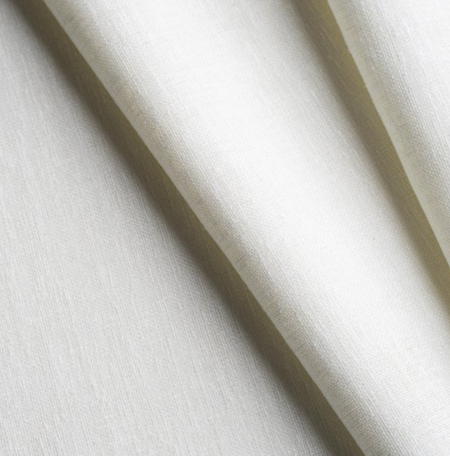 Close-up of beige fabric with a smooth texture and gentle folds.
