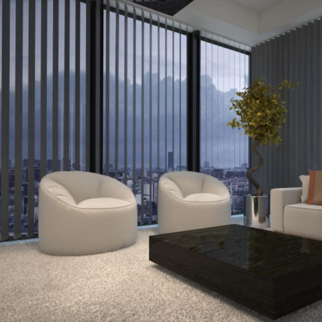 Modern living room with two white rounded chairs, a black coffee table, a white sofa with a pillow, a potted plant, and floor-to-ceiling windows showing a cityscape and cloudy sky.