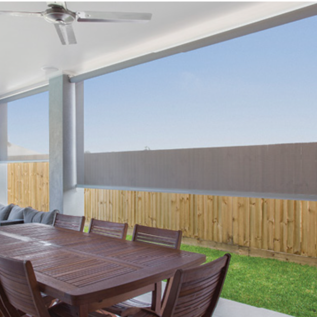 Patio with dining table and chairs under a roof, enclosed by a wooden fence, with a mesh privacy screen and a ceiling fan