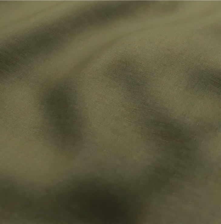 Close-up of olive green fabric with smooth texture and soft folds.