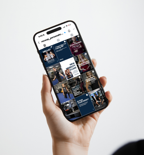 Hand holding a smartphone displaying a fitness app with workout videos and motivational content.
