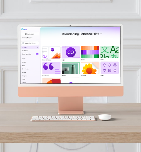 An iMac computer displaying design templates on a desk with a keyboard and mouse