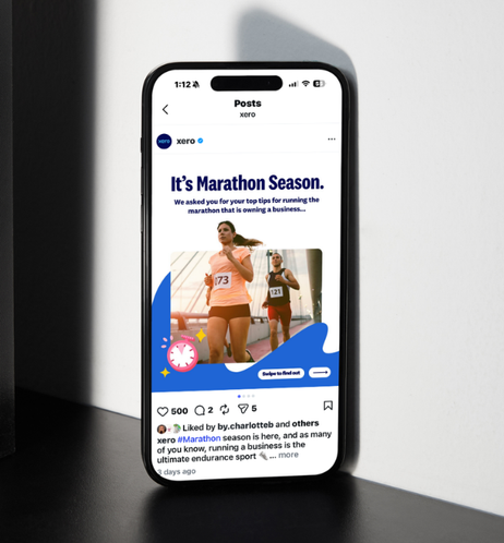 Smartphone displaying a social media post about marathon season with a photo of female runners in a race.