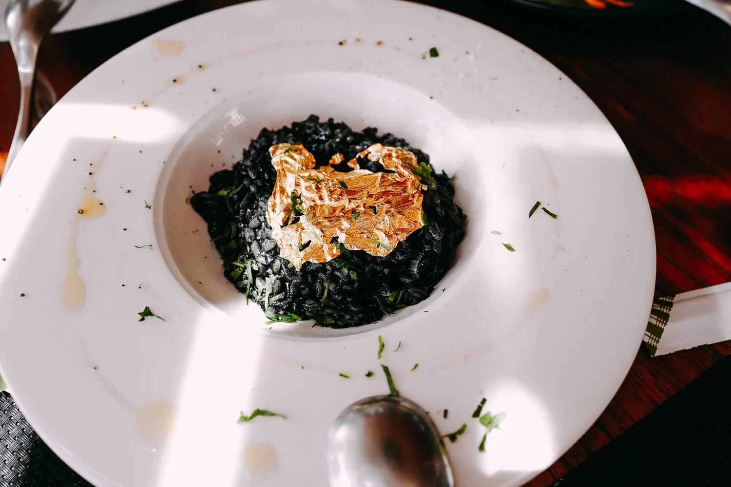 RISOTTO with cuttlefish ink and gold leaves.