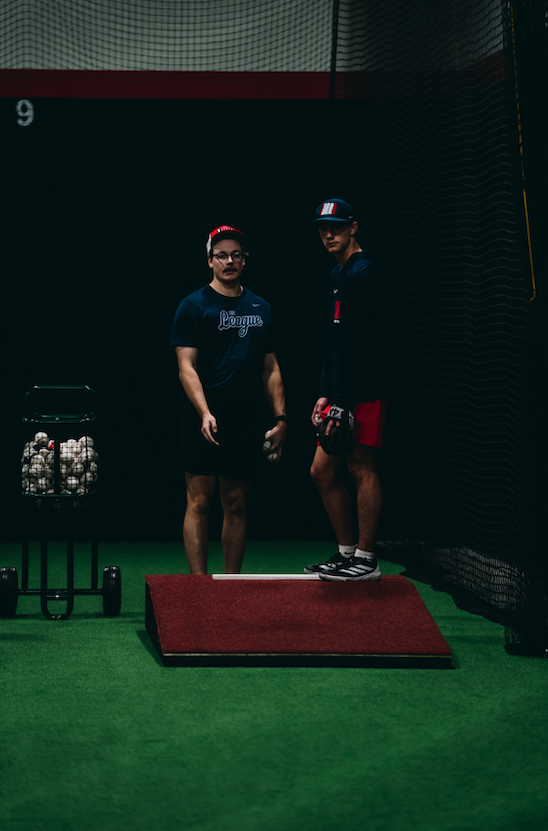 Two pitchers on an indoor mound during Development Academy bullpen work