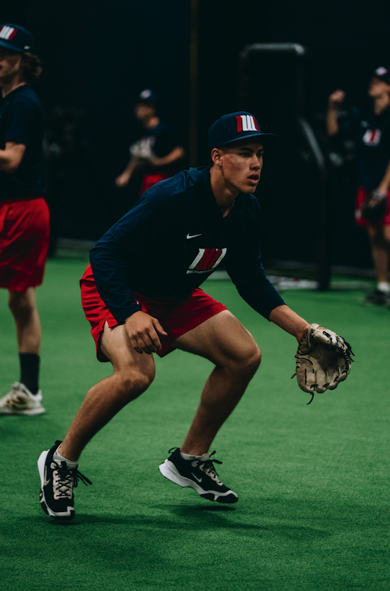 Infielder in a ready stance with glove on indoor turf
