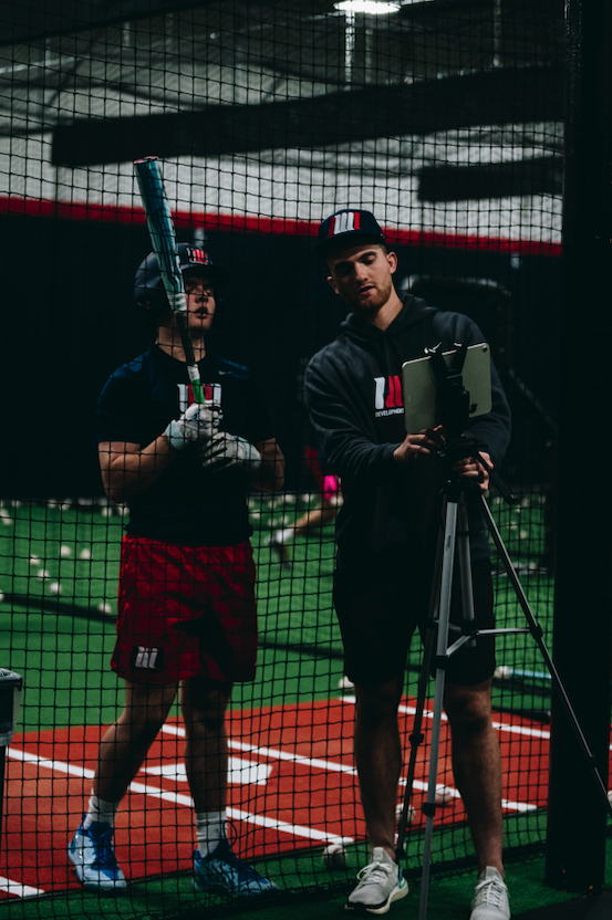 Coach filming a hitter with video analysis at Northwest Nationals baseball training